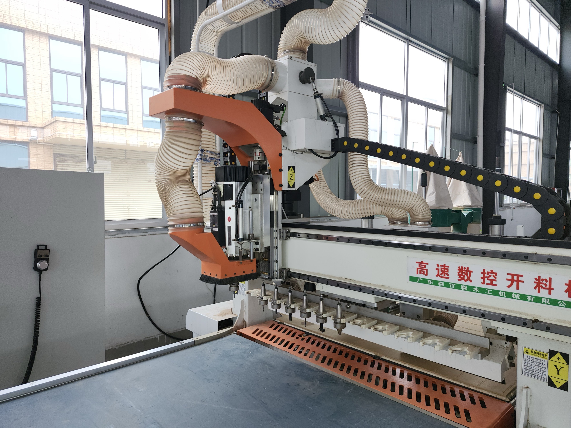 Computer-controlled panel machining equipment with dust-extraction hoses