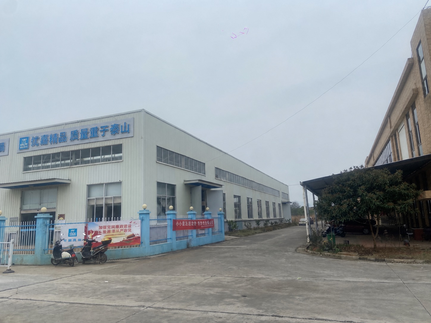 Workshop building with blue YOJIA signage above the entrance