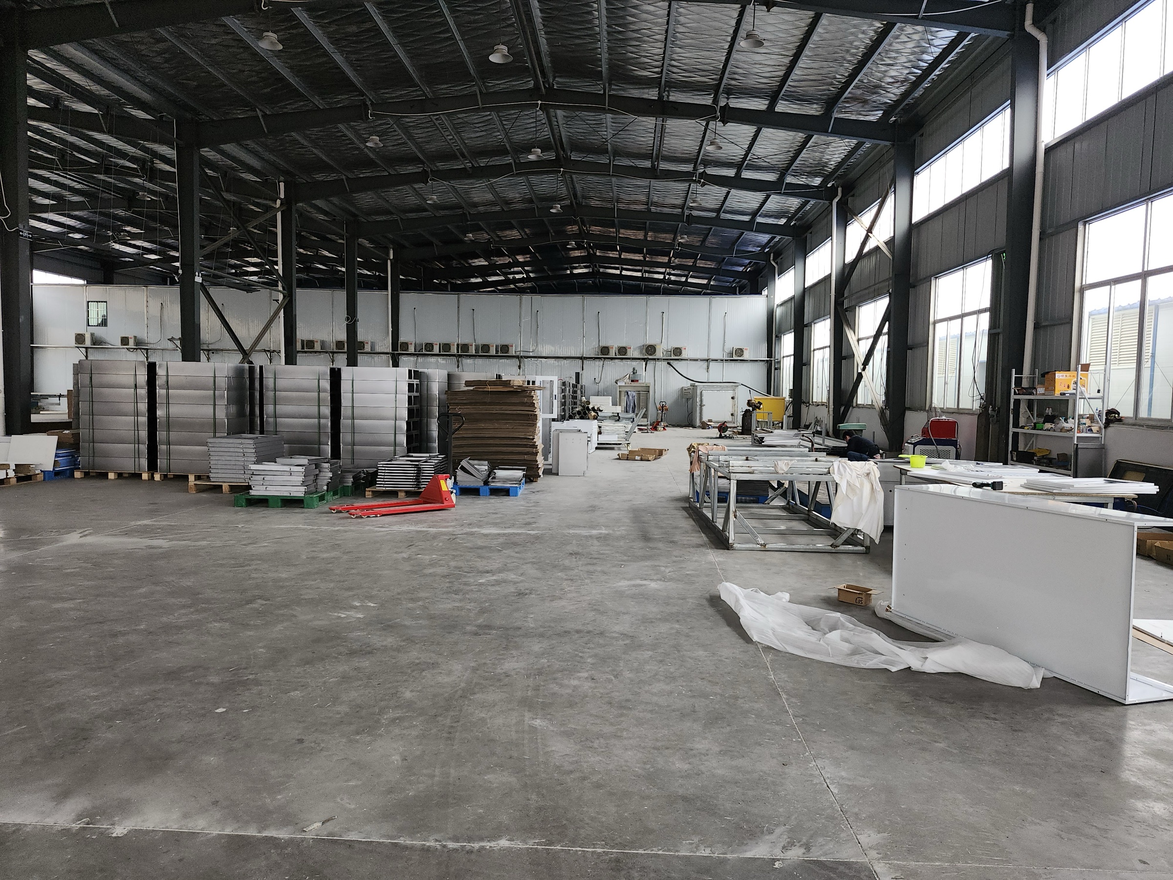 Wide production hall with prepared components, worktables, and pallets