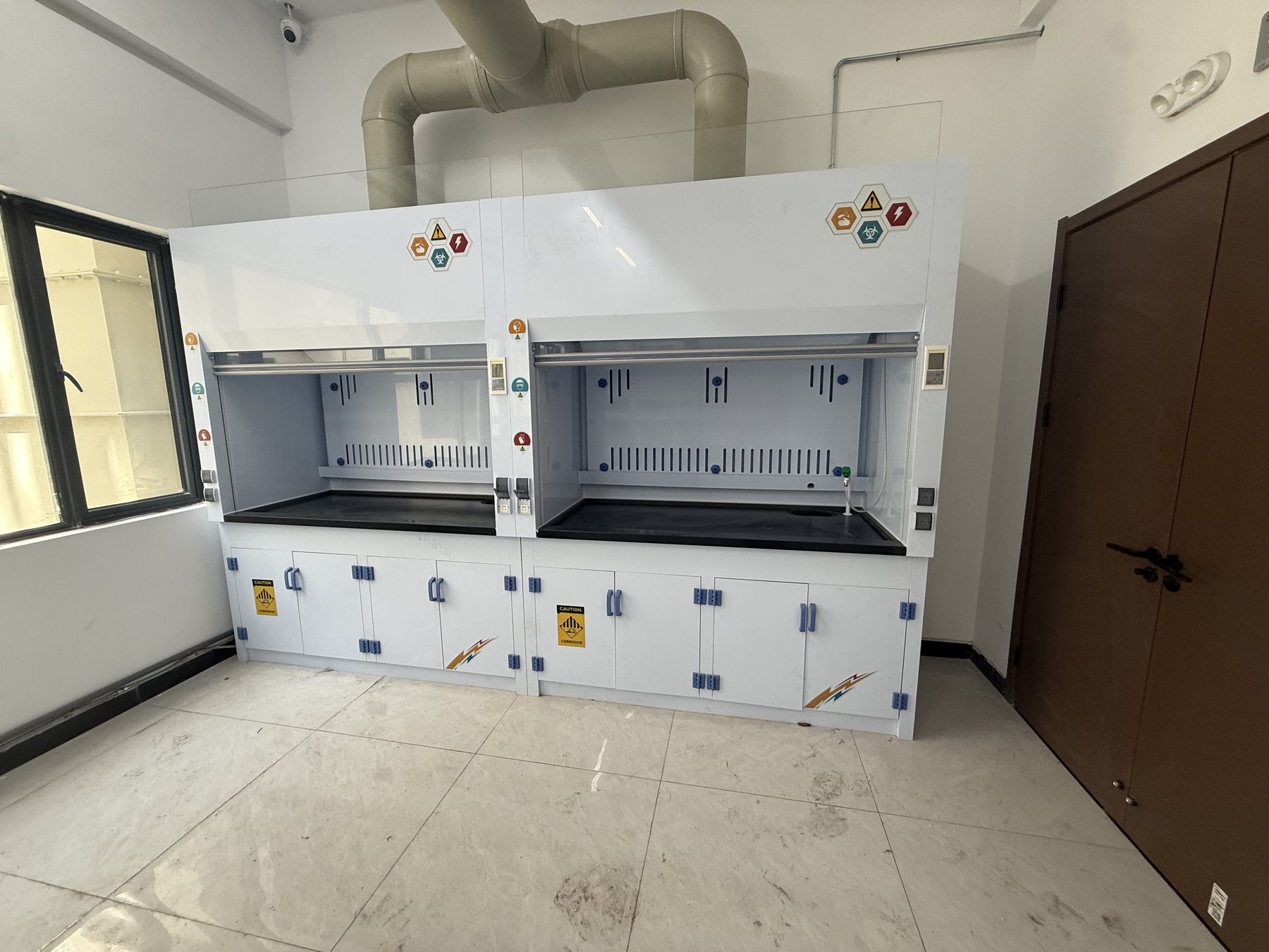 Floor-standing laboratory fume hood installed beside a doorway