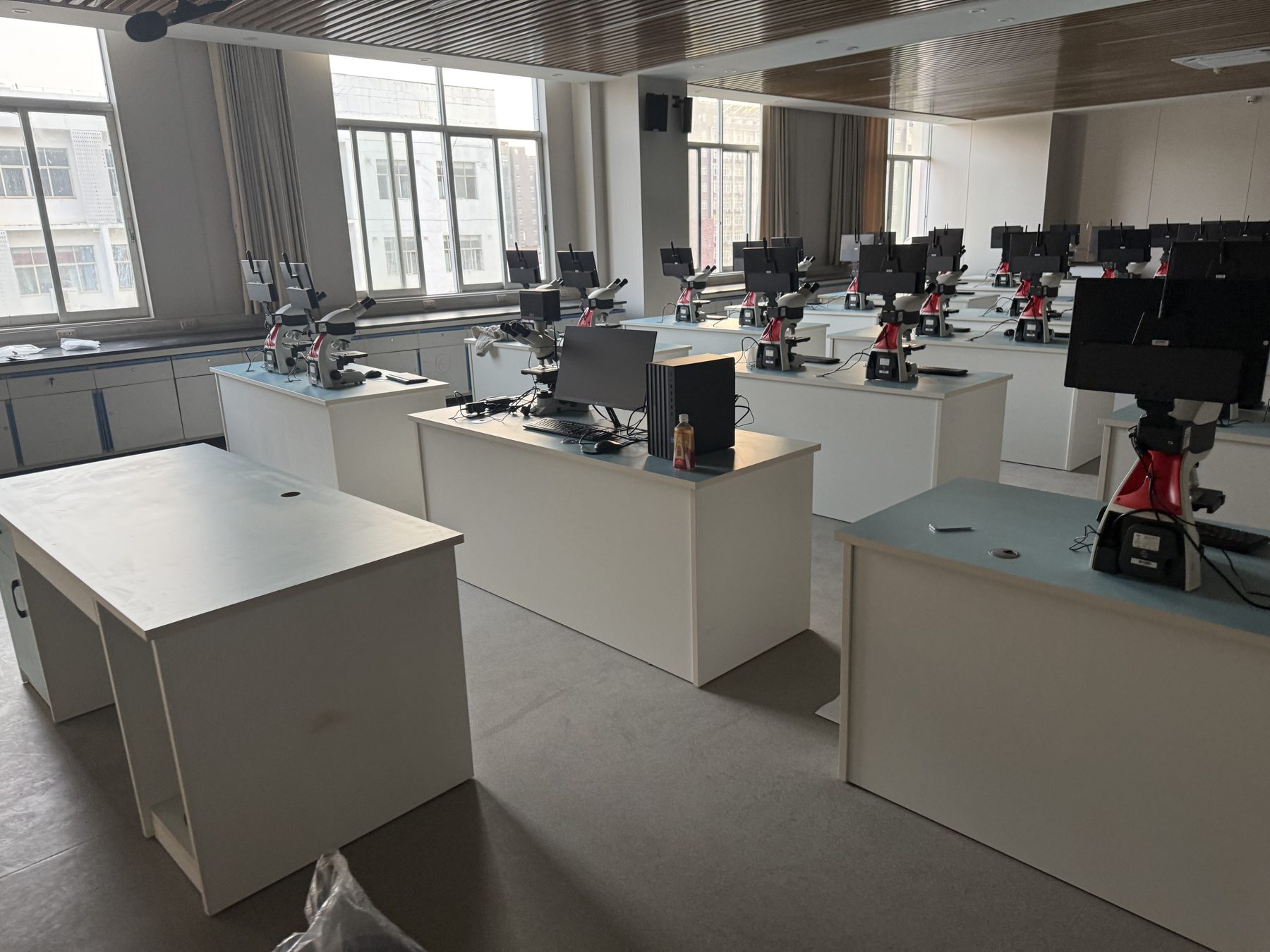 Laboratory equipment supported on individual workstations in a bright room