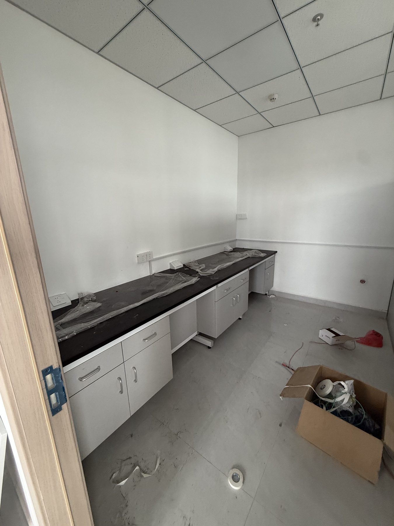 Compact laboratory wall bench with drawers, cupboards, and open knee spaces