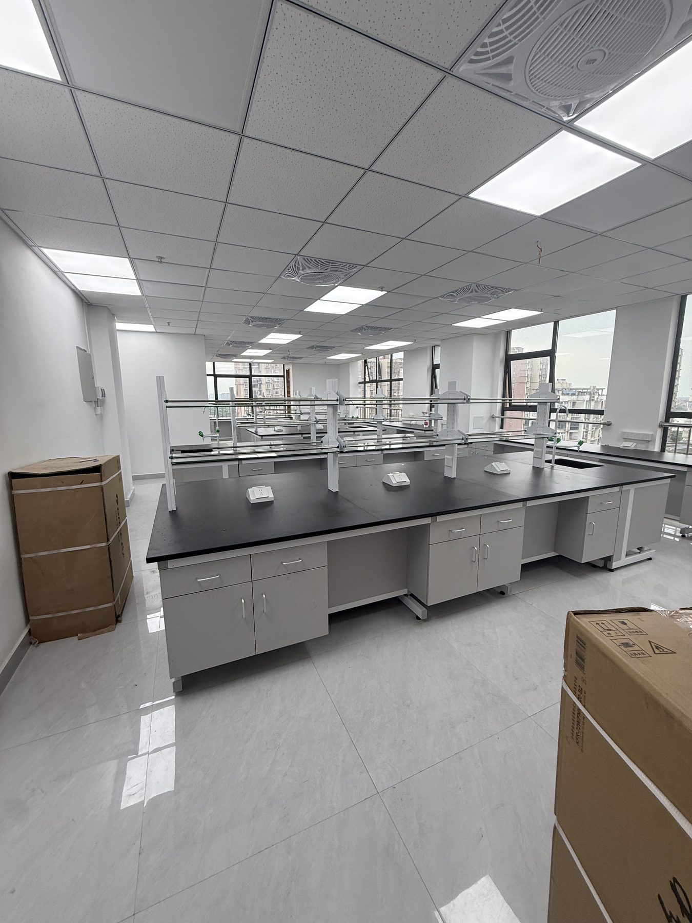 Laboratory furniture installation area with protected packages and benches being positioned