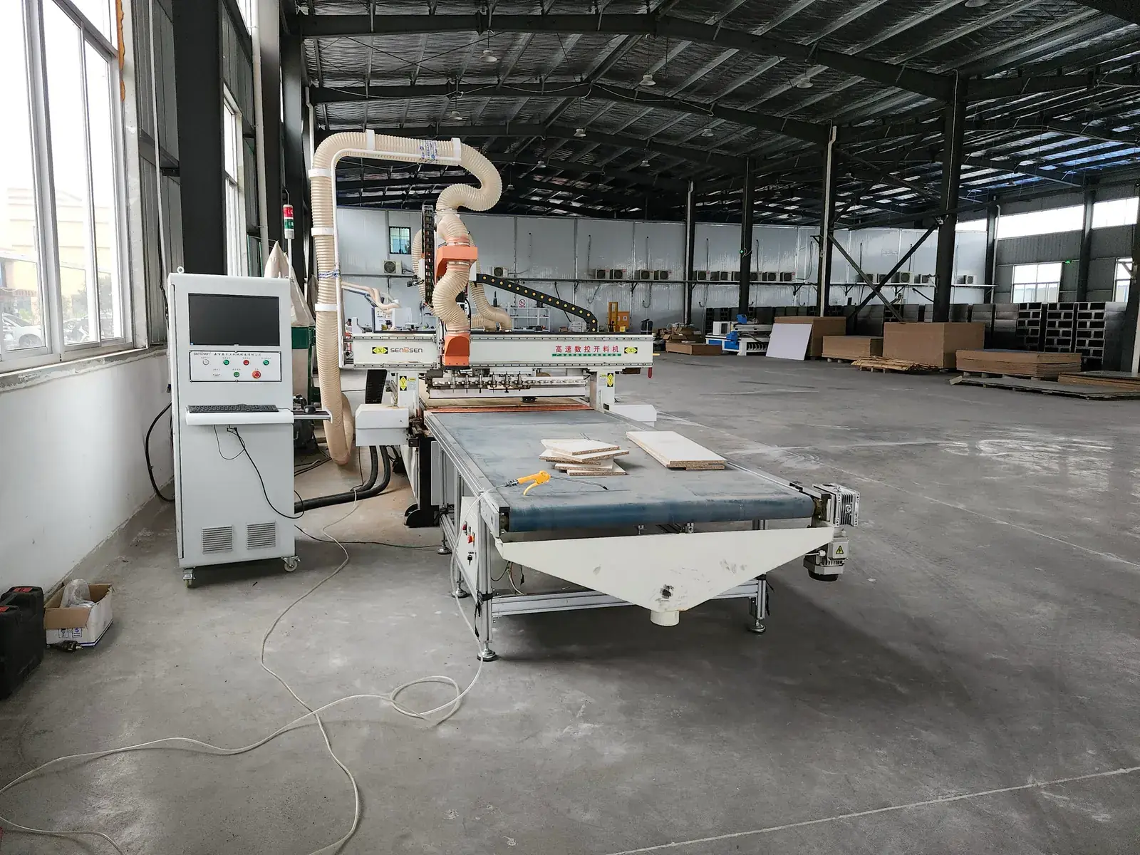Computer-controlled routing station with panel material on the feed table