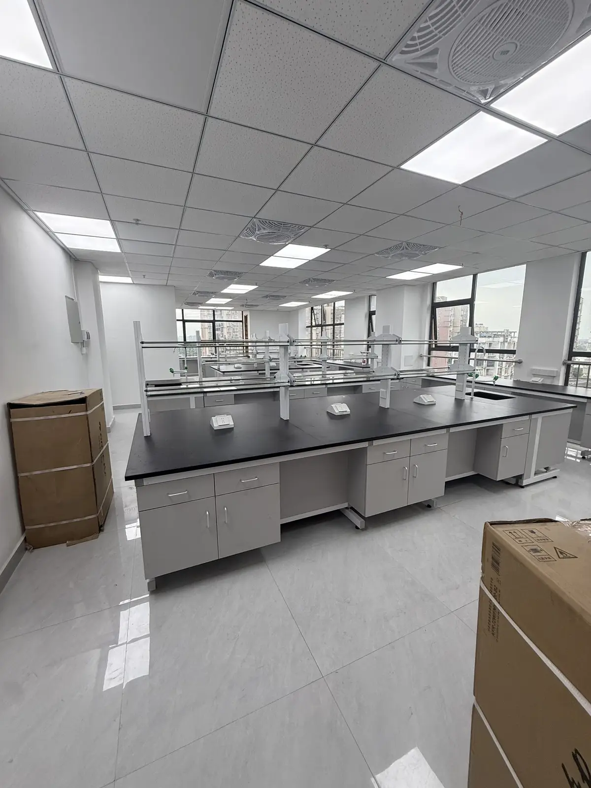 Laboratory furniture installation area with protected packages and benches being positioned
